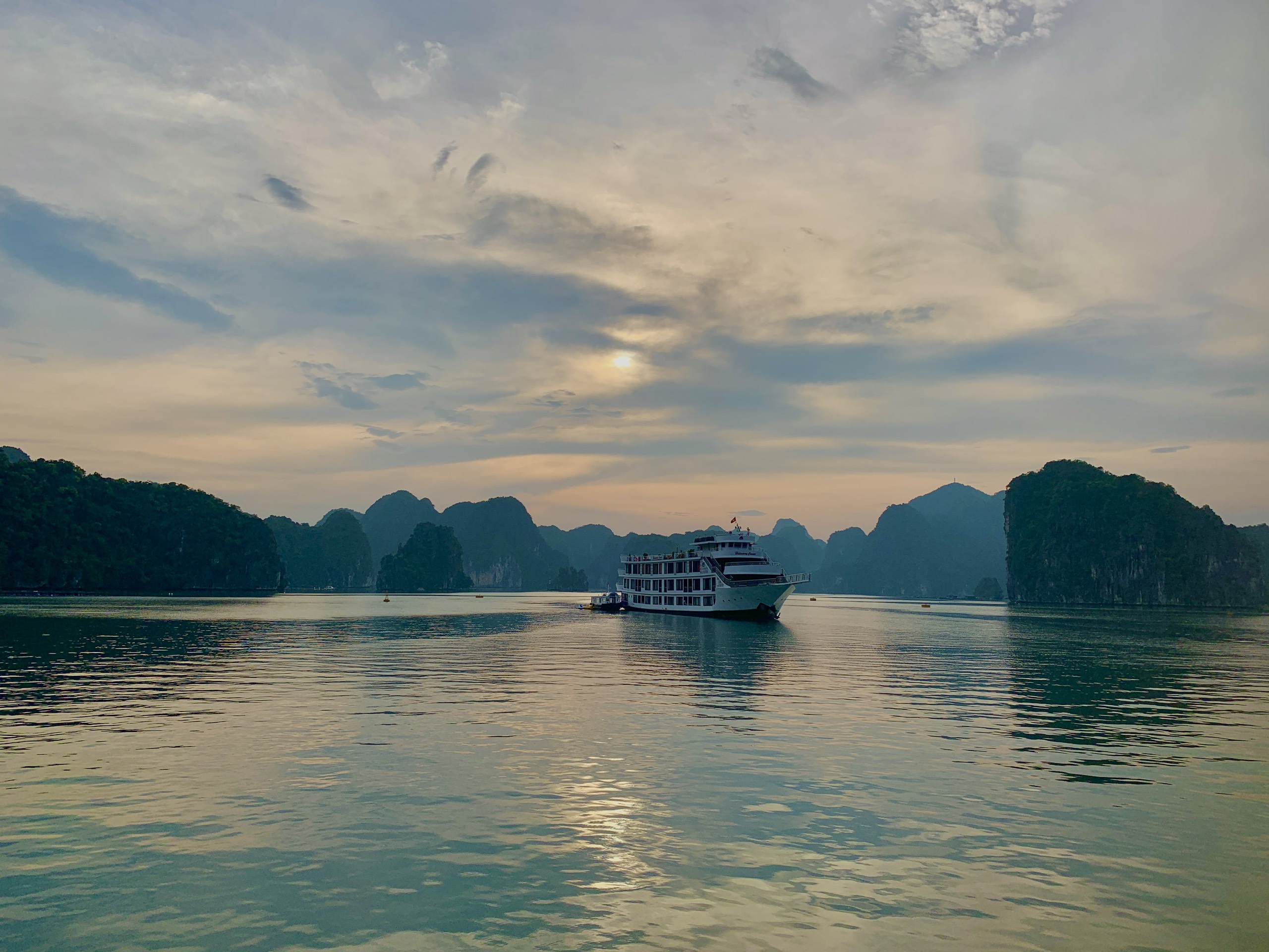 Cruise boat at dusk among limestone islands in Lan Ha Bay, Cat Ba Island