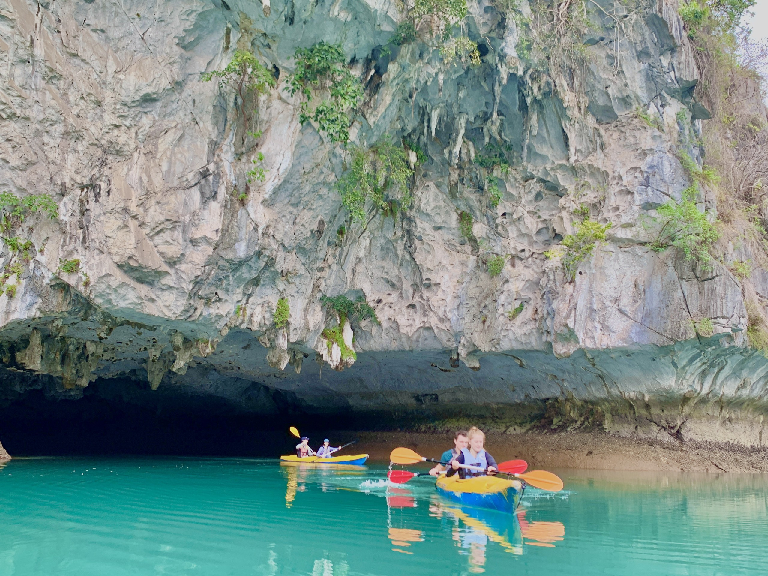 Group of travellers standing on a floating bamboo platform in a calm bay, Cat Ba