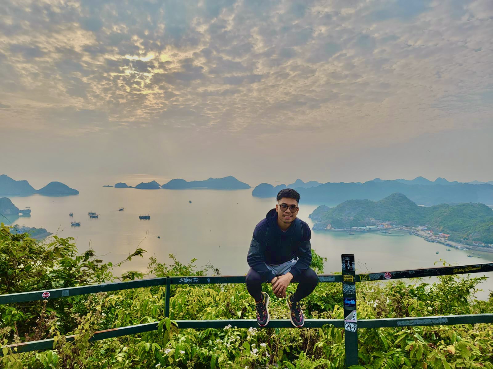 Traveller resting and looking out at limestone mountains and green fields, Cat Ba