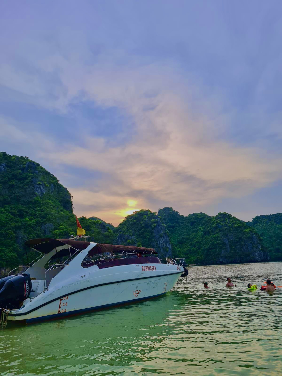 Pink and purple sky over the jungle-covered limestone hills of Cat Ba Island