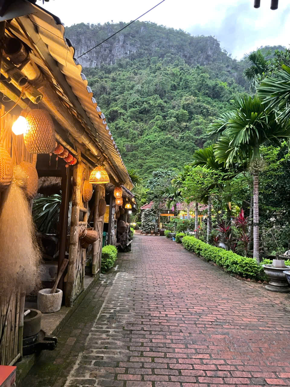 Lantern-lit brick garden path at Lan Homestay, Viet Hai Village Cat Ba Island Vietnam at dusk