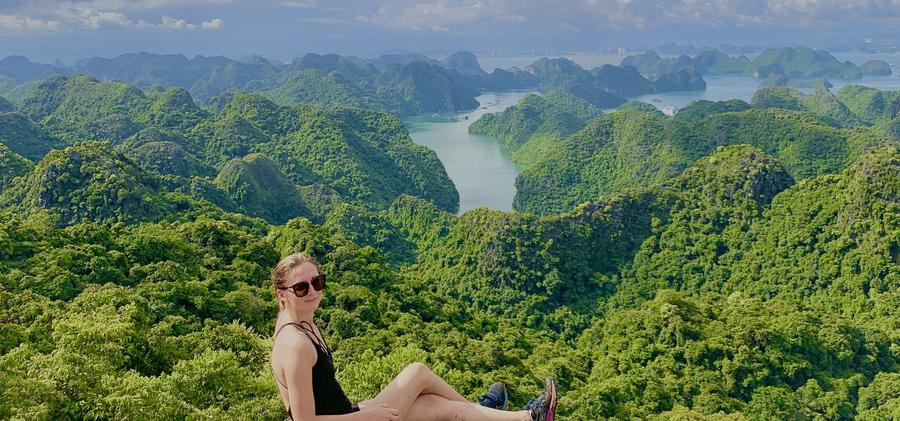 Solo hiker admiring panoramic 360-degree view of Lan Ha Bay and Ha Long Bay from Navy Peak summit, Cat Ba National Park