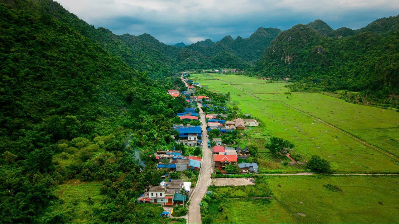 Aerial view of Viet Hai village surrounded by green fields and limestone mountains, Cat Ba Island