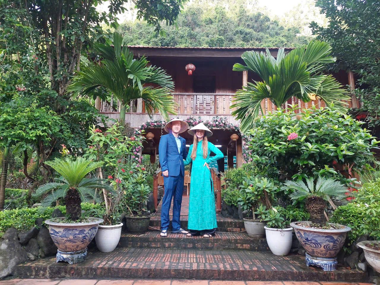 Couple in traditional ao dai in the garden at Lan Homestay, Viet Hai Village