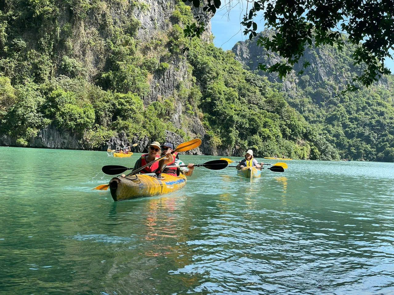 Group kayaking through a limestone lagoon in Lan Ha Bay