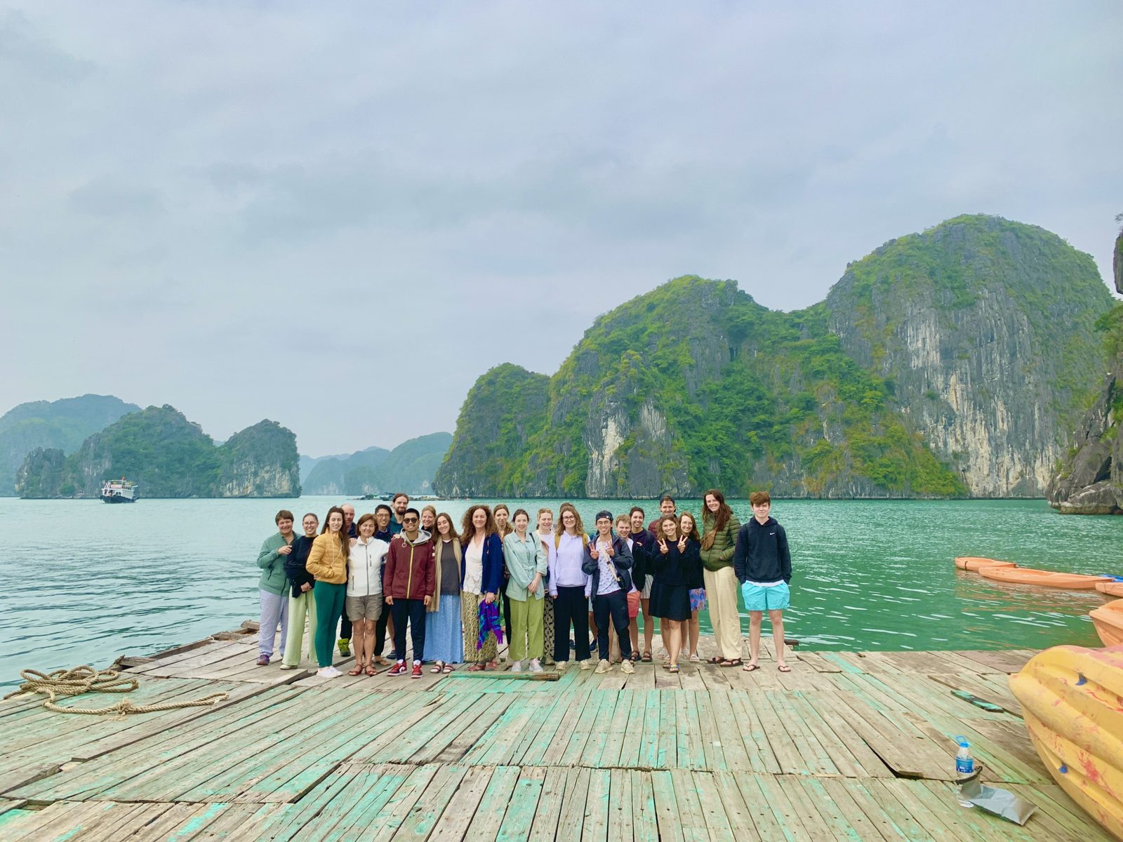 Group standing on a floating bamboo platform in Lan Ha Bay