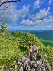 Hiker standing on a limestone summit above the jungle, Cat Ba Island