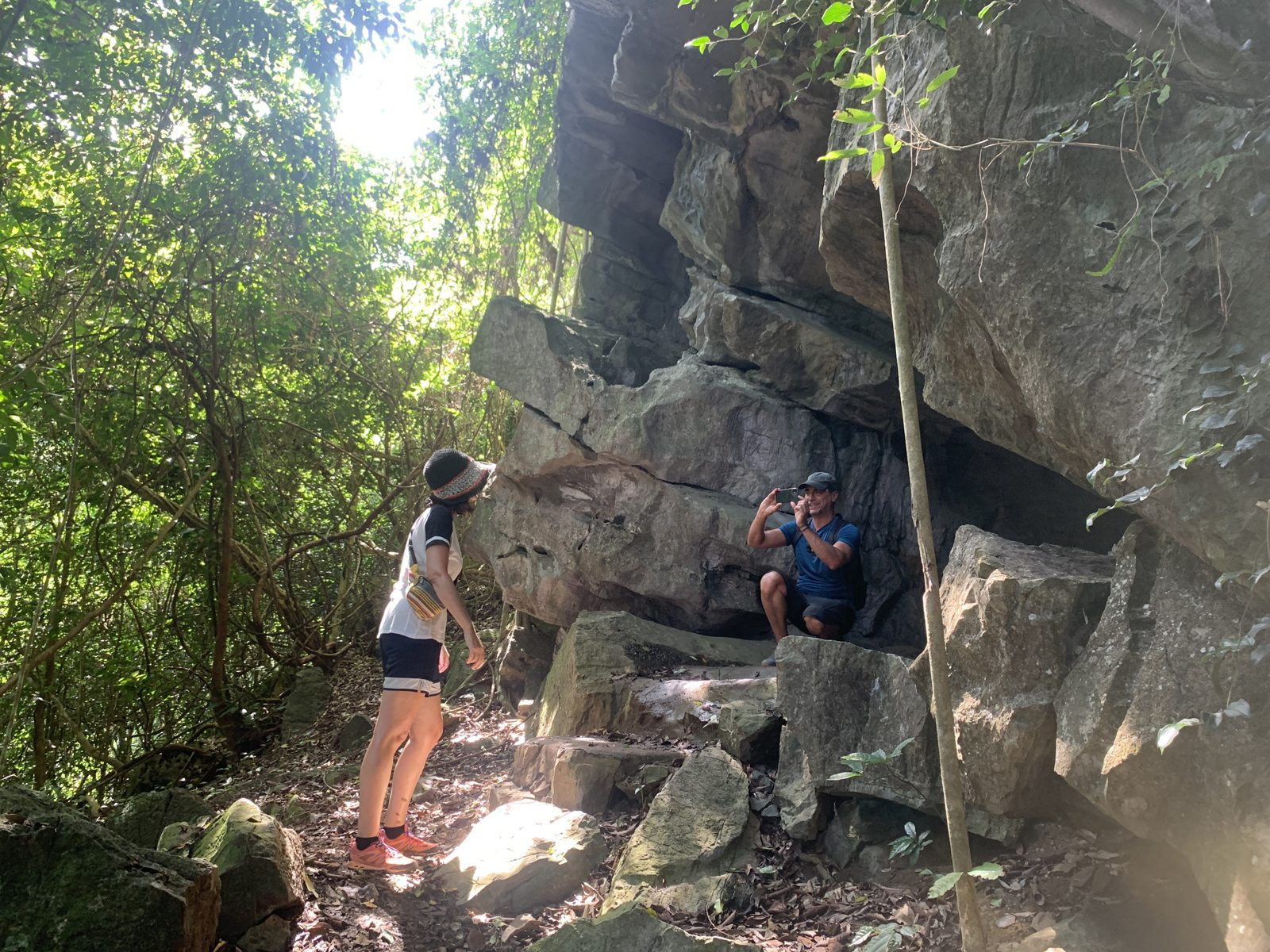 Hikers climbing over rocks on a Cat Ba National Park trail