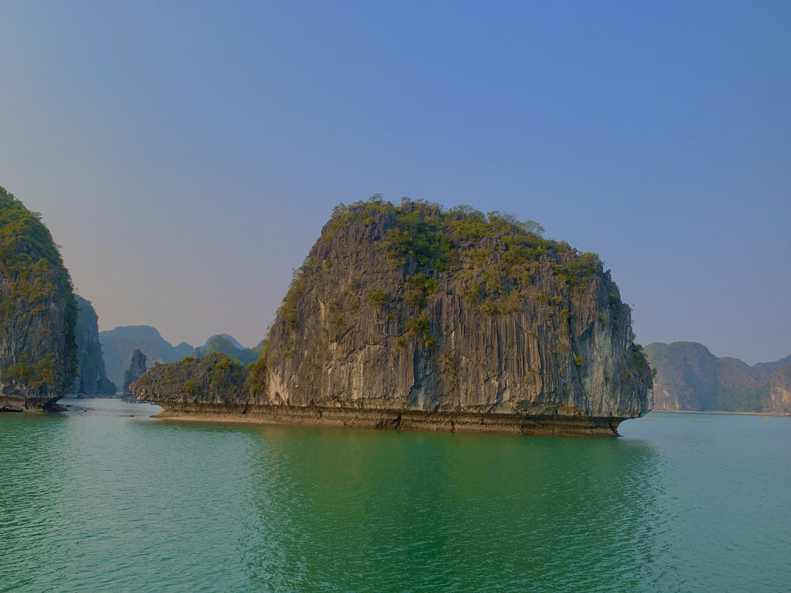 Lone karst island surrounded by green water, Lan Ha Bay