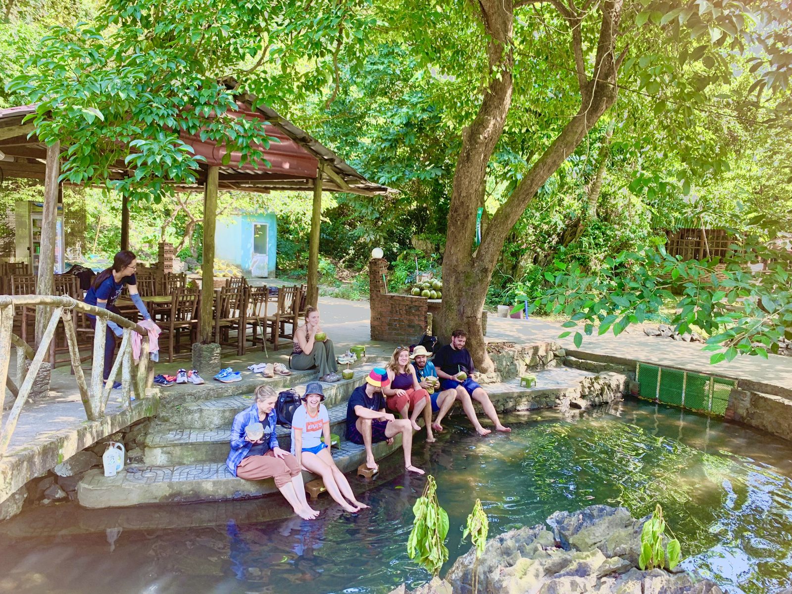 Guests sitting at the natural spring fish spa in Viet Hai Village, Cat Ba Island