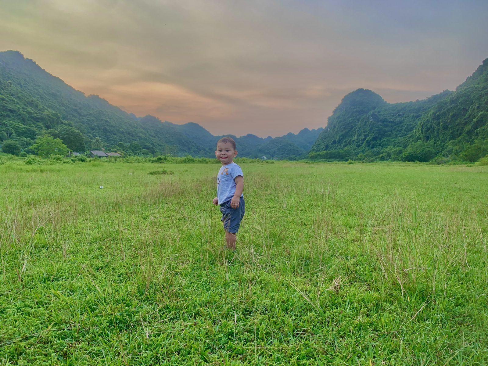 Person standing in a green field in the Viet Hai valley, Cat Ba Island