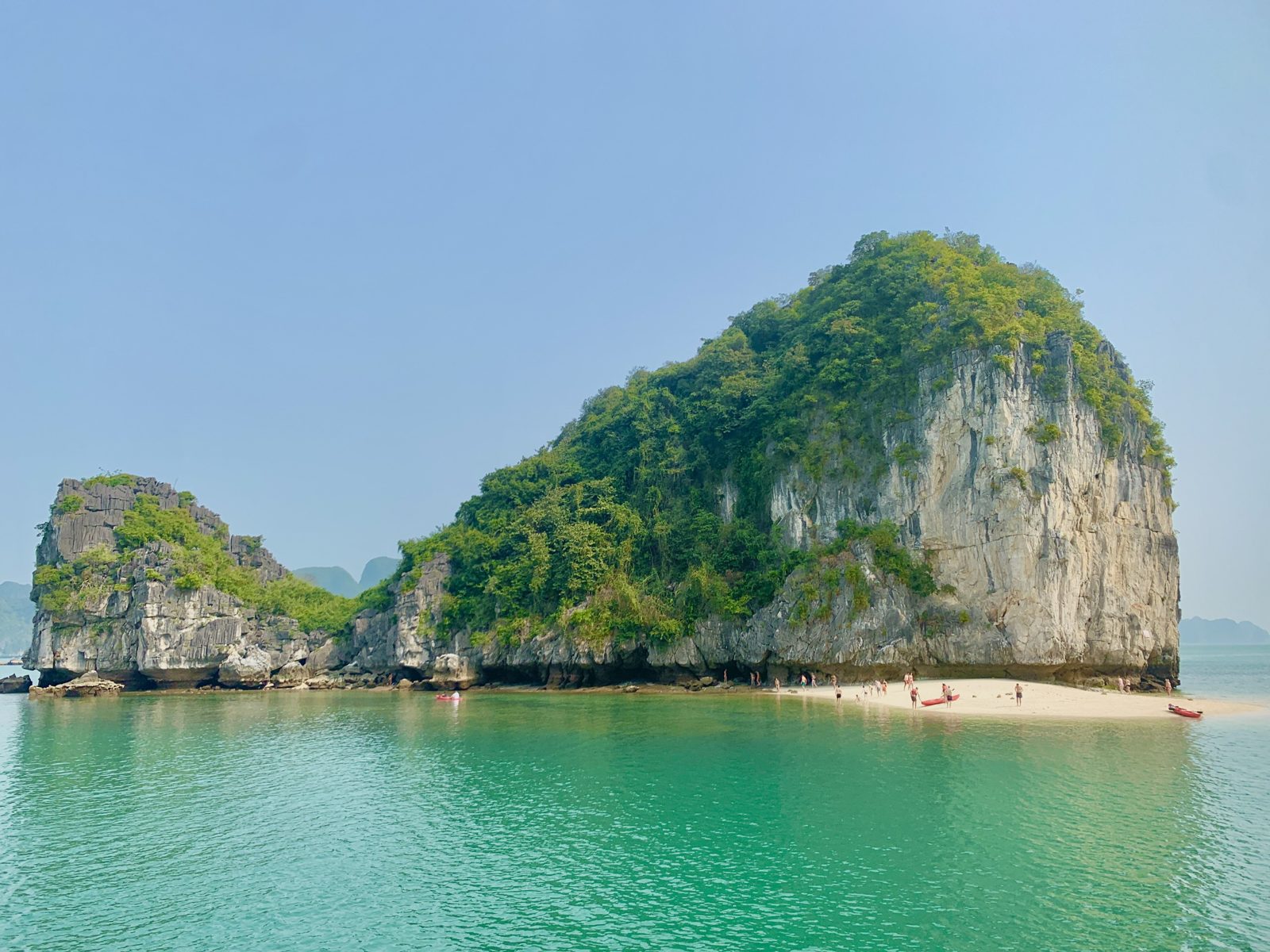 Sandy beach on a karst island with green water, Lan Ha Bay