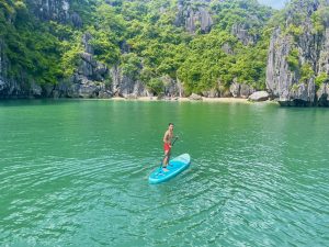 Paddleboarder crossing a limestone lagoon in Lan Ha Bay