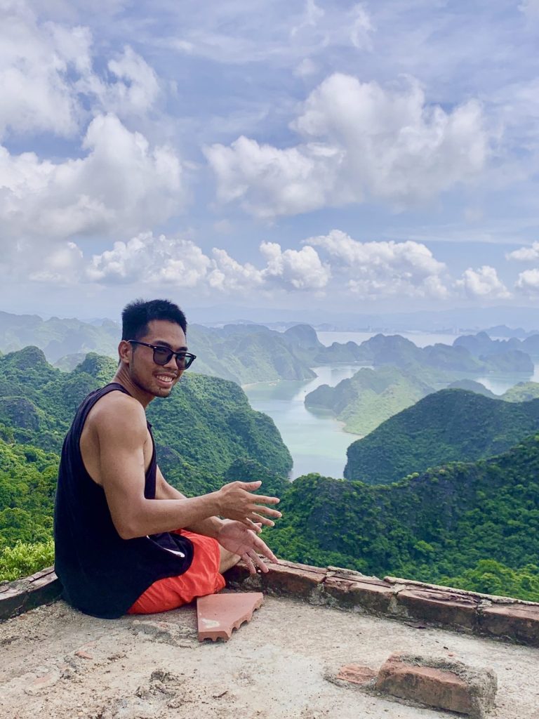 Traveller sitting at a viewpoint above Cat Ba National Park