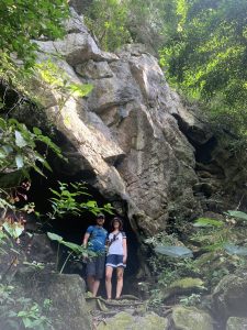 Travellers standing at a cave mouth in the Cat Ba jungle