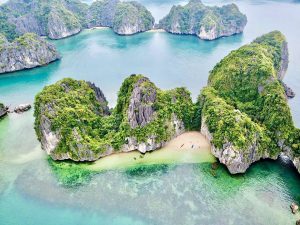 Aerial view of a turquoise lagoon and beach between karst islands, Lan Ha Bay