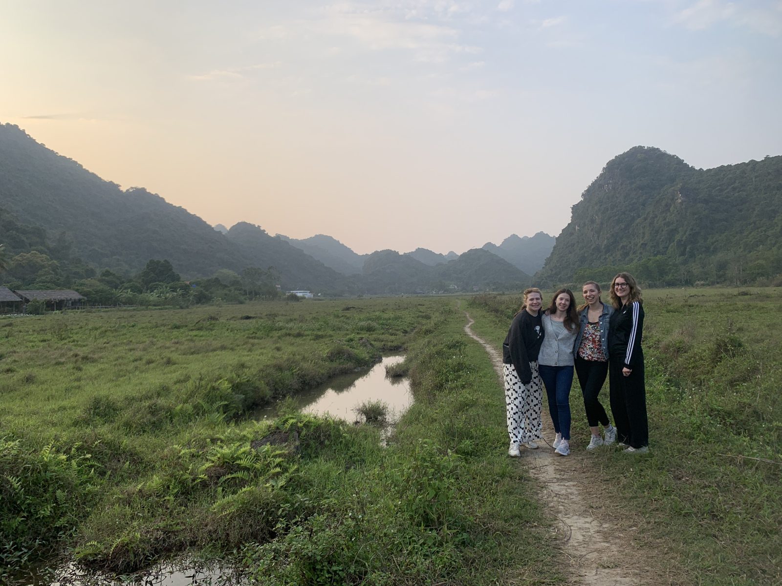 Group walking the flat path through Viet Hai valley in the evening light, Cat Ba Island