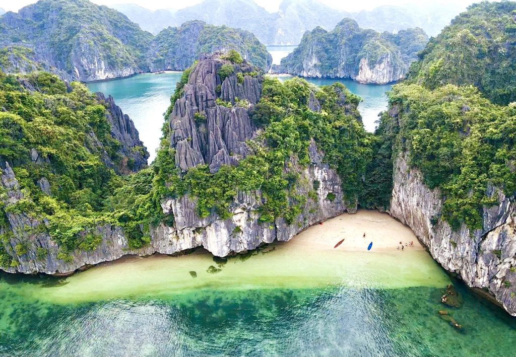 White sand beach in a limestone cove with turquoise water, Lan Ha Bay